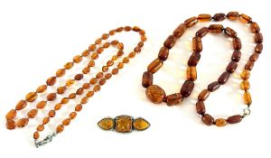 A collection of amber jewellery including two necklaces and a brooch.