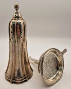 A silver sugar caster with finial, together with a white metal tea strainer of trumpet form, total