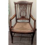 A pierced back elbow chair with rush seat, height of seat 41cm, overall height 95cm.