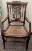 A pierced back elbow chair with rush seat, height of seat 41cm, overall height 95cm.