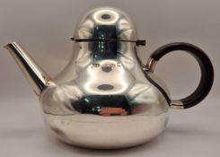 A silver teapot of rounded form with wooden handle, hallmarked Birmingham 1972, maker Robert