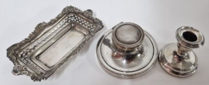An intricate pierced and embossed silver dish, hallmark rubbed, together with a silver candlestick