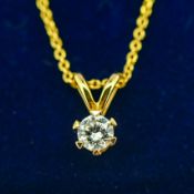 A 14ct yellow gold round brilliant cut diamond solitaire pendant on a gold plated silver chain,