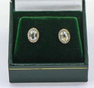 A pair of 9ct yellow gold oval aquamarine and round brilliant cut diamond cluster studs, aquamarines