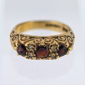 A three stone garnet ring set with four diamonds, set in 9ct yellow gold, size J, approx 3.5g.
