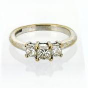 A three stone diamond ring, set in 18ct white gold, marked '86' on the inside band, size L/M.