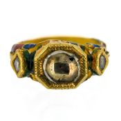 A gold and enamel ring set with three clear stones, possibly Indian origin.