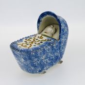 An 18th century Prattware ceramic cradle with child.