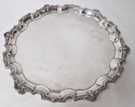 A silver salver or tray, hallmarked Sheffield 1967, on three scroll feet and embossed rim by