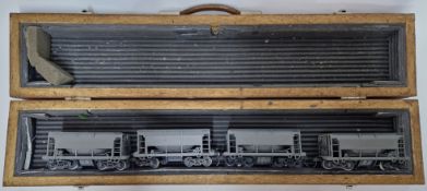 Four O-gauge wagons, boxed, matt grey plastic.