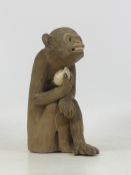 Far Eastern Clay Model of a Seated Monkey holding a plum with glass eyes. Height: 16.5cm