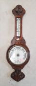 Early 20th century carved oak aneroid barometer with integral thermometer, height 73cm.