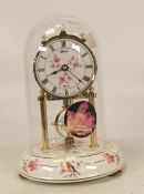 Hermle anniversary clock, ceramic base decorated with birds and flowers under a glass dome.