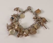 Silver charm bracelet with multiple charms, 77.6g.