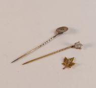 Two 9ct gold pins with stones missing, 1.9g and a 10ct leaf,0.6g. (3)