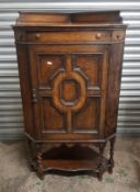 Oak corner cabinet raised on stretchered barley twist supports, key present, height 115cm.