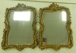 A pair of ornate vintage style mirrors with a plaster type frame in a gold tone Baroque/Rococo style