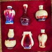 A collection of Chinese porcelain miniature vases decorated in red high fired glazes, in original