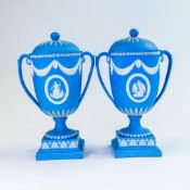A pair of Wedgwood two handled urn & covers, each decorated with cameos & swags to front and rear,