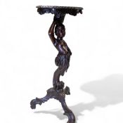 Carved dark wooden Torchere, depicting a Blackamoor figure with decorative carved foliage detail.
