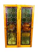 A pair of Victorian stained glass panels, the centre panel hand painted with a swan, in wooden