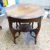 Carved oak occasional table on wheeled castors with lower shelf. H74cm x W73cm.