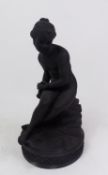 A Wedgwood black basalt figurine of a seated Psyche, on a circular base, with impressed marks,