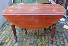 Mahogany dropleaf dining table on brass castors, 70cm H and diameter when extended 112cm.
