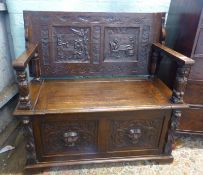A carved oak monk's bench with lion mask front panels 107cm W x 95cm H x 50cm D