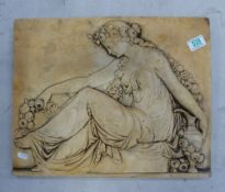 A large plaster wall hanging depicting a Grecian style goddess sitting amongst flowers. 37cm high