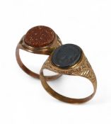Two 9ct gold signet rings, one set with black centurions head stone, size V and the other with