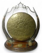 Bovine Table Top Dinner Gong 19th/20th century, featuring a brass circular gong held by chains