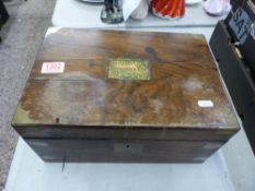 A Victorian mahogany campaign-style writing slope with ink wells and some partial contents, in