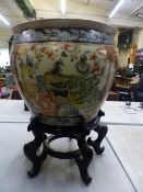 A 20th Century Chinese polychrome ceramic fishbowl of large proportions, raised on a hardwood stand,