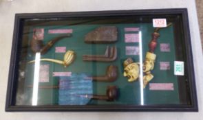 Framed collection of antique pipes, size 52cm x 29.5cm x 7.5cm.