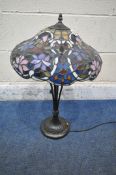 A TIFFANY STYLE TABLE LAMP, the shade with foliate details, of various colours, raised on a shaped