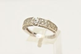 A CUBIC ZIRCONIA DRESS RING, a central circular cut cubic zirconia prong set in white metal, leading