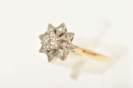 A YELLOW METAL DIAMOND CLUSTER RING, set with a central round brilliant cut diamond, within a