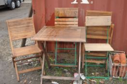 A SELECTION OF FOLDING HARDWOOD GARDEN FURNITURE including a folding table with two matching
