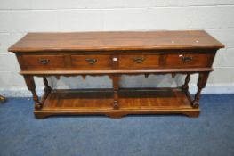 A THEODORE ALEXANDER HARDWOOD DRESSER BASE, fitted with four frieze drawers, a wavy apron, raised on