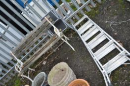 A CAST IRON AND WOODEN SLATTED GARDEN BENCH, with distressed slats, width 122cm, along with two step