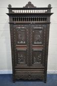AN EARLY 20TH CENTURY FRENCH CARVED OAK TWO DOOR CUPBOARD, the Breton detail to the doors, above a