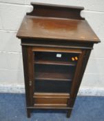 A 20TH CENTURY MAHOGANY MUSIC CABINET, with a raised back, the single glass door enclosing