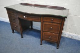 AN EDWARDIAN MAHOGANY SERPENTINE DESK, with an arrangement of seven drawers, on square tapered