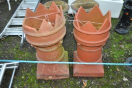 A PAIR OF TERRACOTTA CHIMNEY POTS, with crown tops, height 70cm, condition report: some losses to