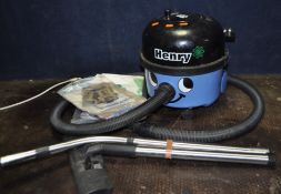 A NUMATIC HVR-200A 'HENRY' VACUUM CLEANER with floor head and pipework along with spare bags, and