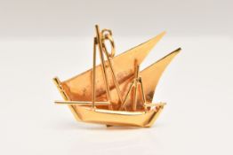 A YELLOW METAL PENDANT, in the form of a ship, fitted with a jump ring for suspension, stamp marks