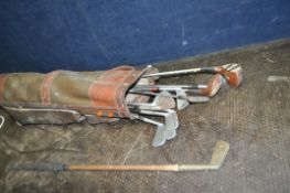 A VINTAGE GOLF BAG CONTAINING CLUBS including a hickory shafted putter