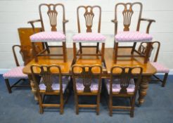 A LARGE 20TH CENTURY OAK WIND OUT DINING TABLE, with three additional leaves, raised on reeded and