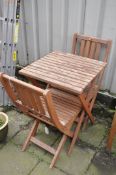 A STAINED BEECH FOLDING GARDEN TABLE AND TWO CHAIRS, condition report: with fsc label, finish